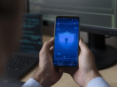 mão segurando um celular com um ícone de segurança e privacidade