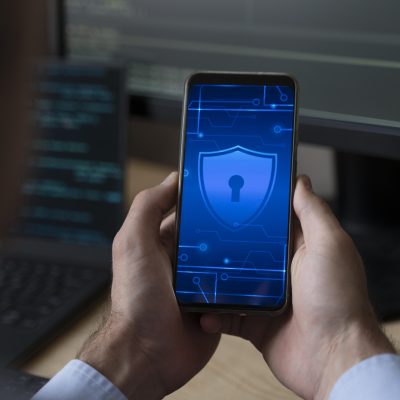 mão segurando um celular com um ícone de segurança e privacidade